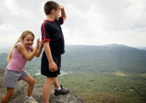 Girl pretends to push brother off a cliff